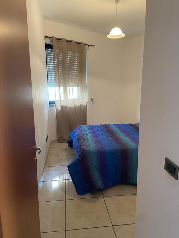 Łóżko lub łóżka w pokoju w obiekcie Appartamento Residence Baia Blu