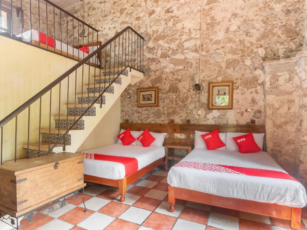 two beds in a room with a staircase at Rancho Hotel El Carmen in Tlapacoyan