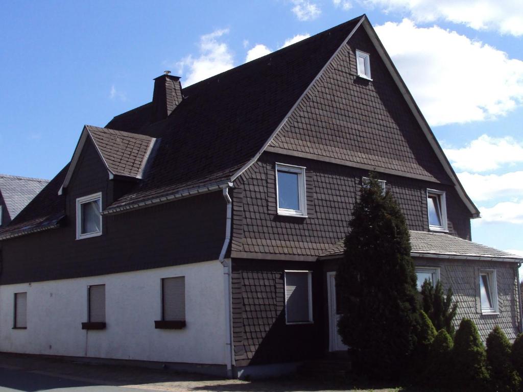 ein großes Haus mit schwarzem Dach in der Unterkunft Holiday home near the ski lift in Winterberg