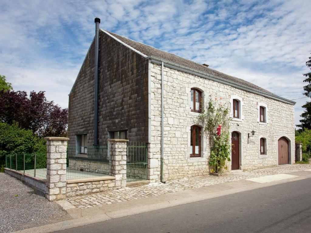 un vieux bâtiment en briques avec une clôture autour de lui dans l'établissement Spacious Holiday Home in Humain with Garden, à Marche-en-Famenne