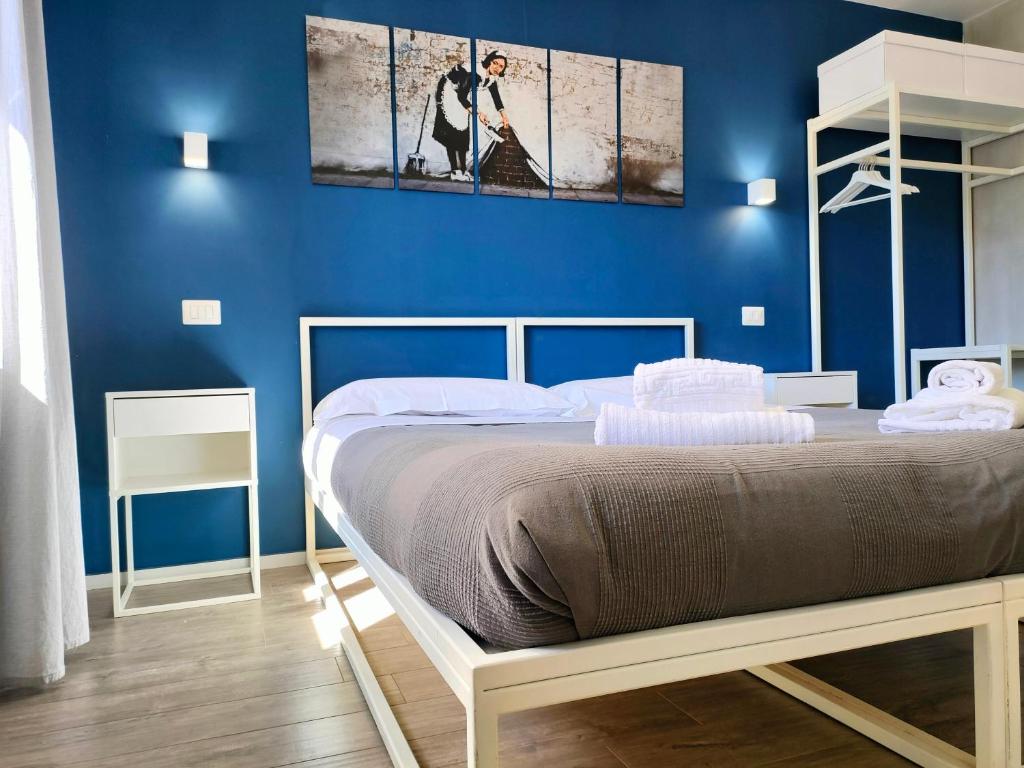 - une chambre dotée d'un lit avec un mur bleu dans l'établissement Central Rooms Matera, à Matera