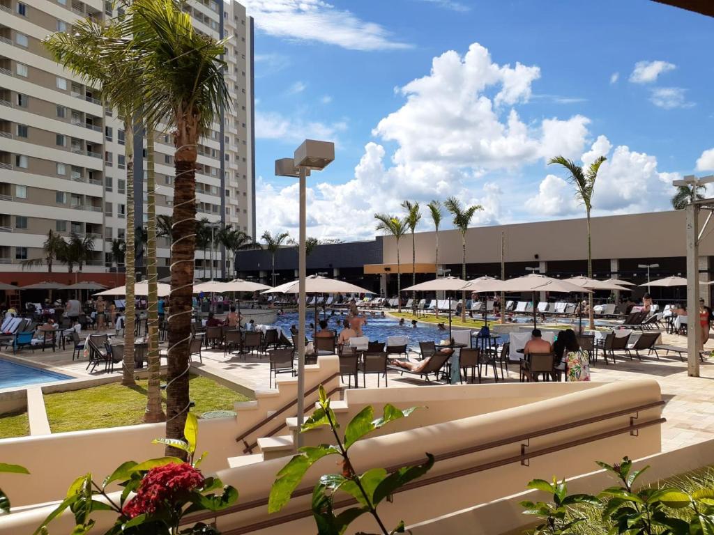 a swimming pool with tables and chairs and a resort at Solar das Águas - Resort Em Olimpia - Ap 2 quartos in Olímpia