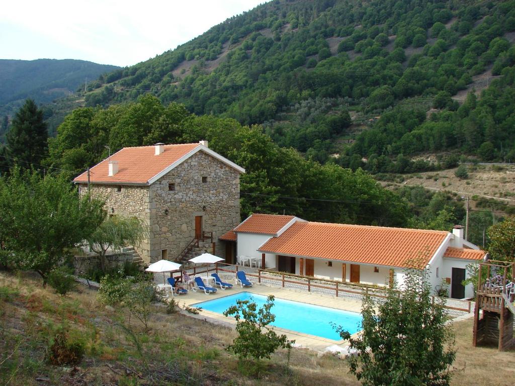 a villa with a swimming pool in front of a mountain at Quinta de Leandres in Manteigas