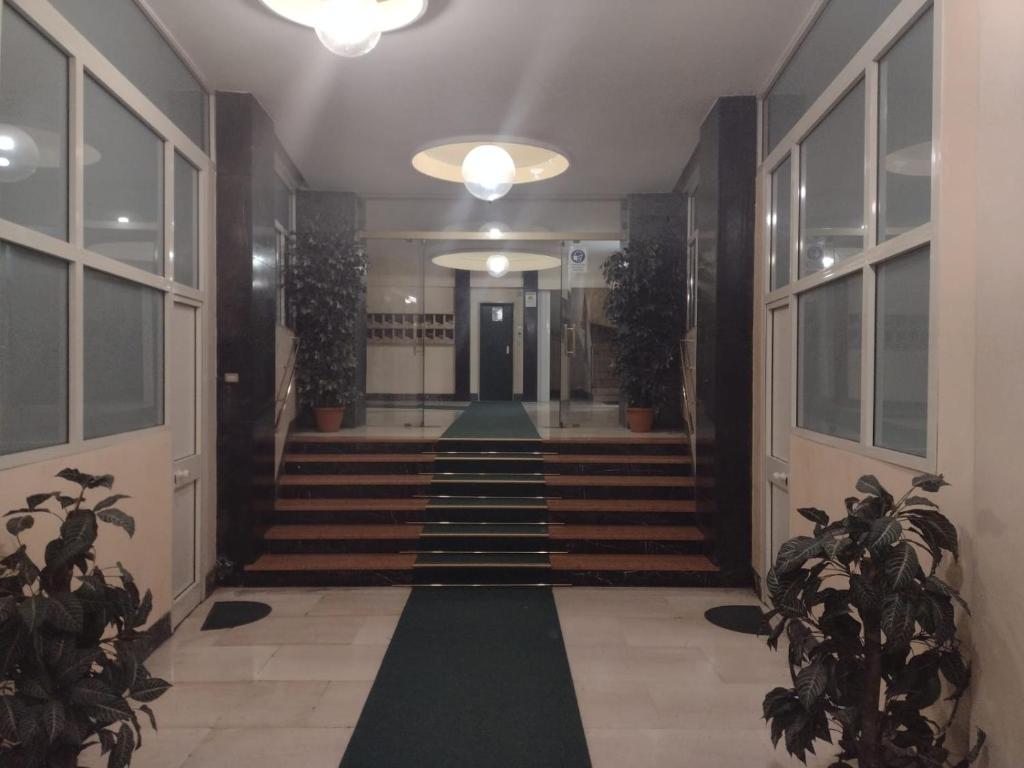 un couloir avec des escaliers et des plantes en pot dans un bâtiment dans l'établissement Vatican Luxury Apartment, à Rome