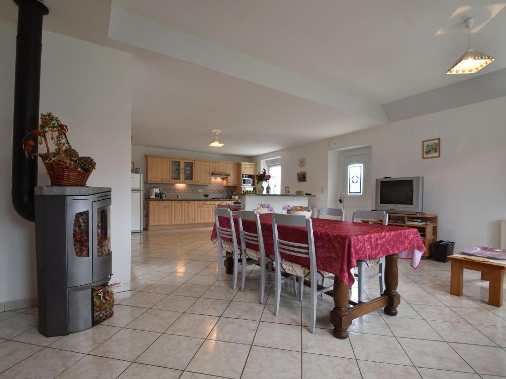 a kitchen and dining room with a red table and chairs at Tasteful holiday home in Plouvara with garden in Saint-Donan