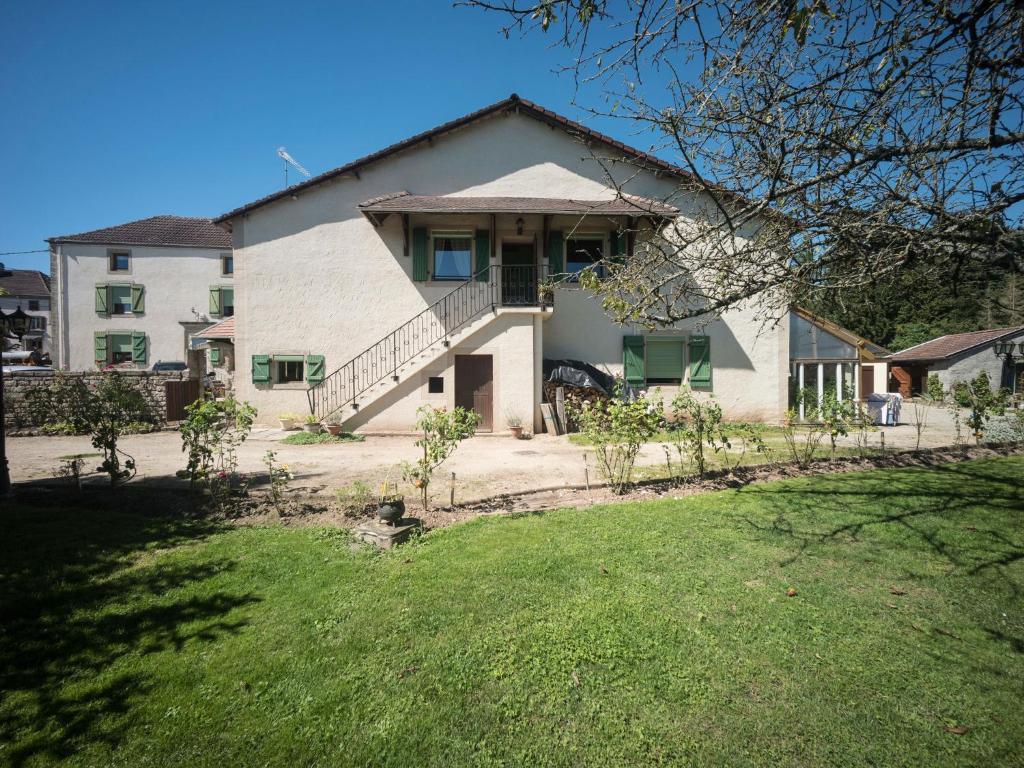 a large white house with a grass yard at Charming flat with barbecue in Dombasle-devant-Darney