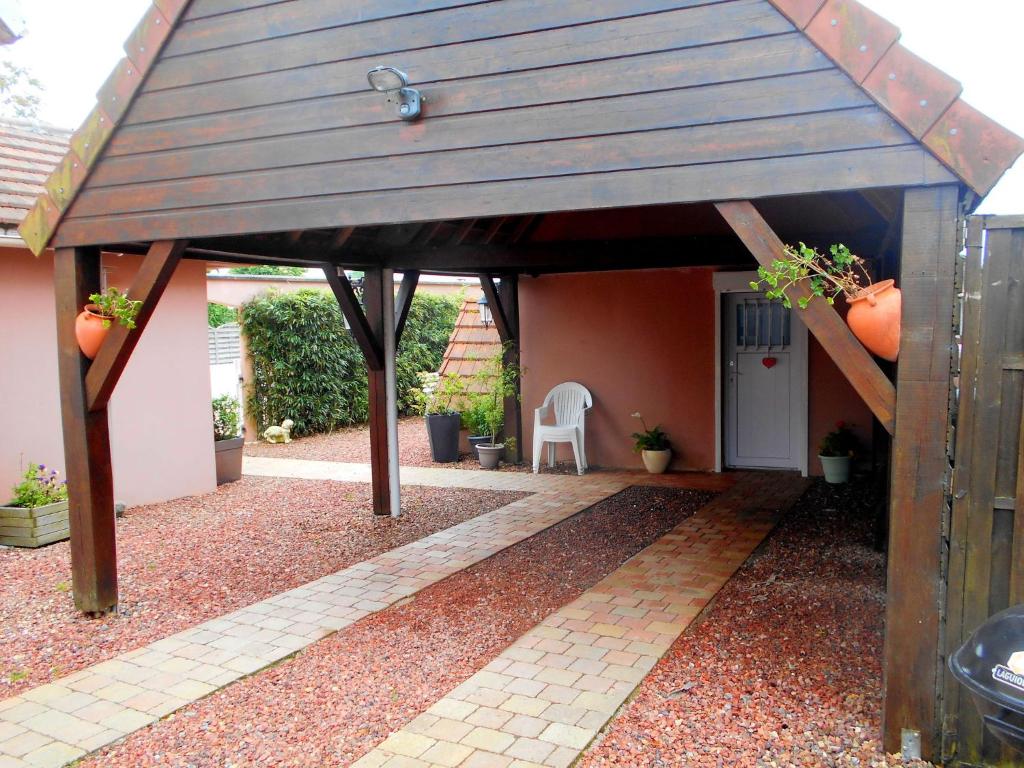 a covered patio with a table and a chair at Cosy house with private pool in Folleville in Sourdon