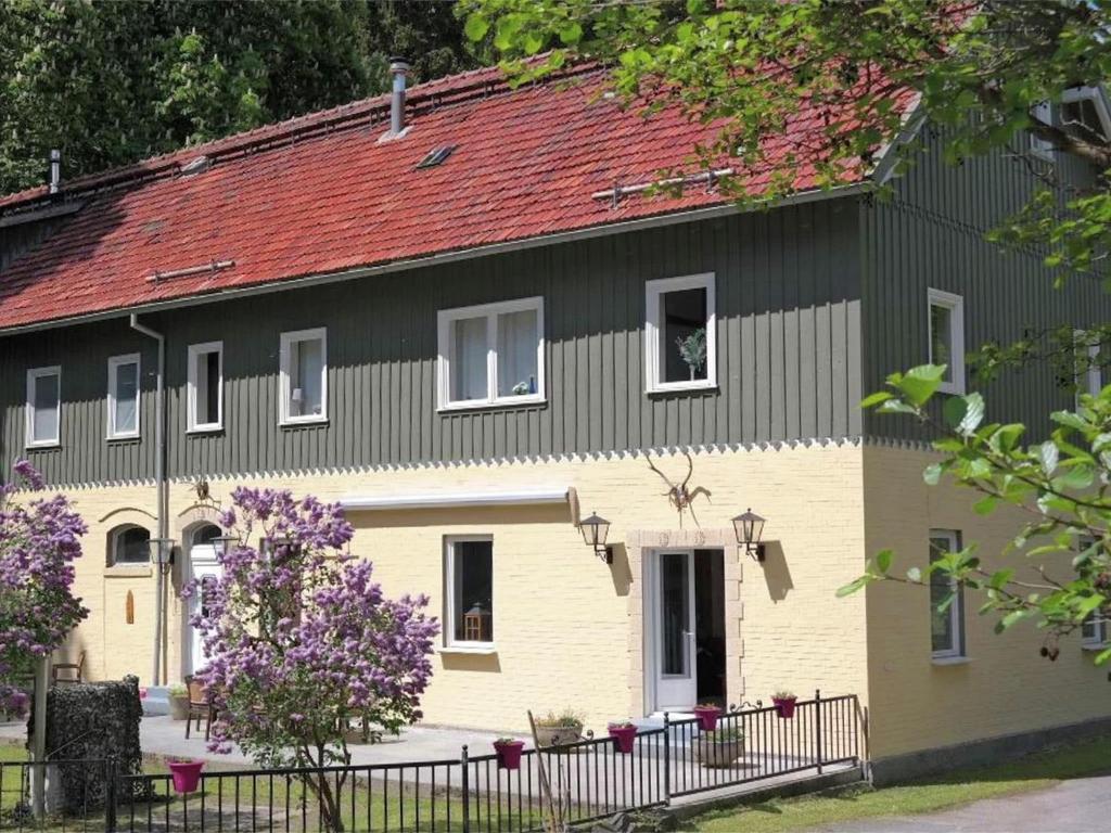 ein großes Haus mit rotem Dach in der Unterkunft Beautiful apartment in a former coach house in the Harz in Elbingerode