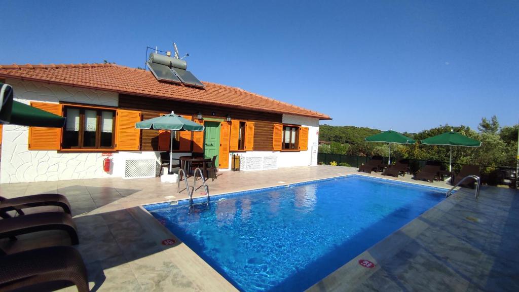 a villa with a swimming pool in front of a house at Gypsy Hill in Ortaca