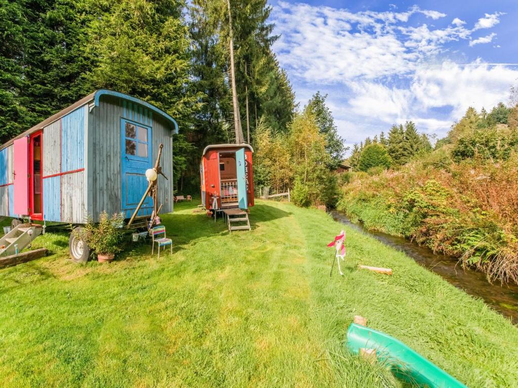a tiny house in a field next to a river at Holiday Home in Houffalize With Terrace in Houffalize