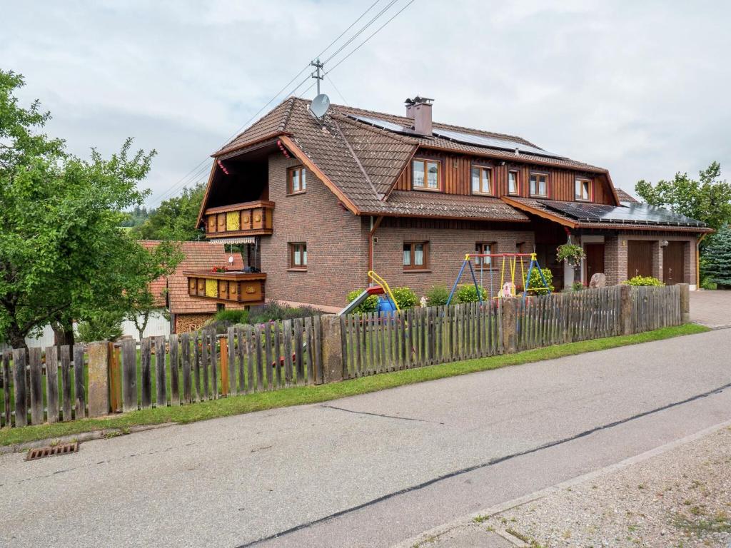 una casa con una valla de madera delante de ella en apartment in Black Forest quiet residential area, en Neuweiler