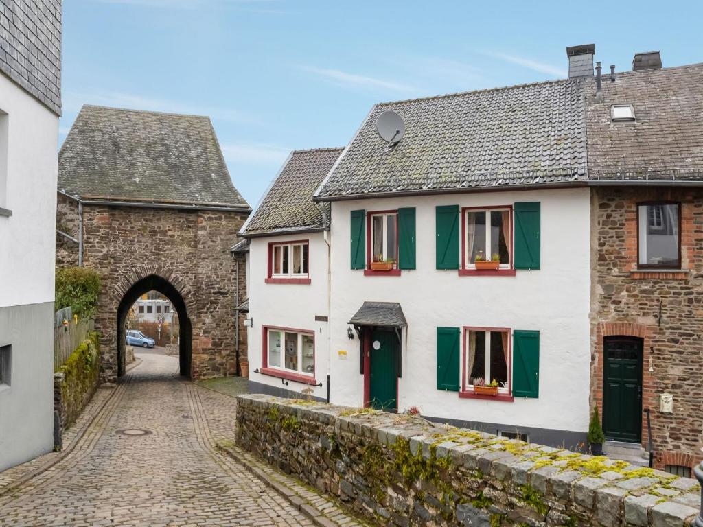 an alley in a medieval town with white houses at Apartment in Hellenthal Reifferscheid with Wellness Oasis in Hellenthal