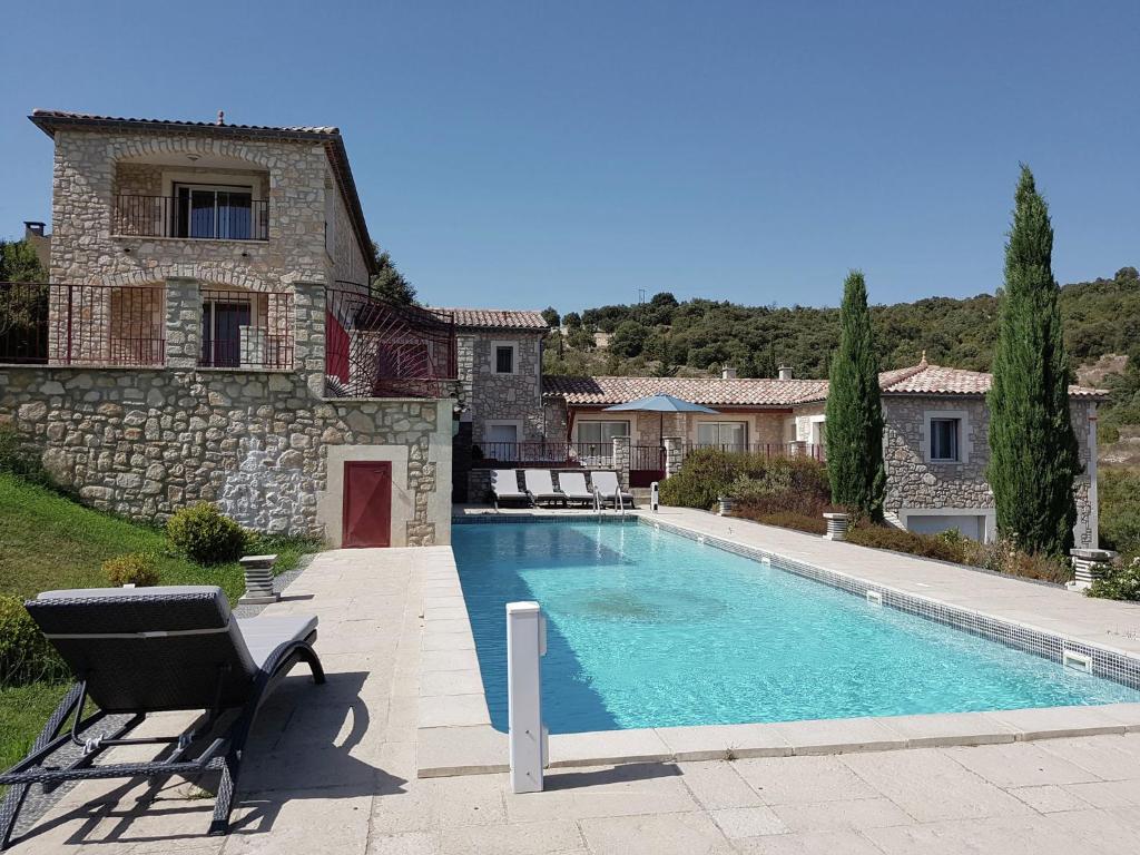 a swimming pool in front of a house at Holiday home with views and private pool in Saint-Victor-de-Malcap