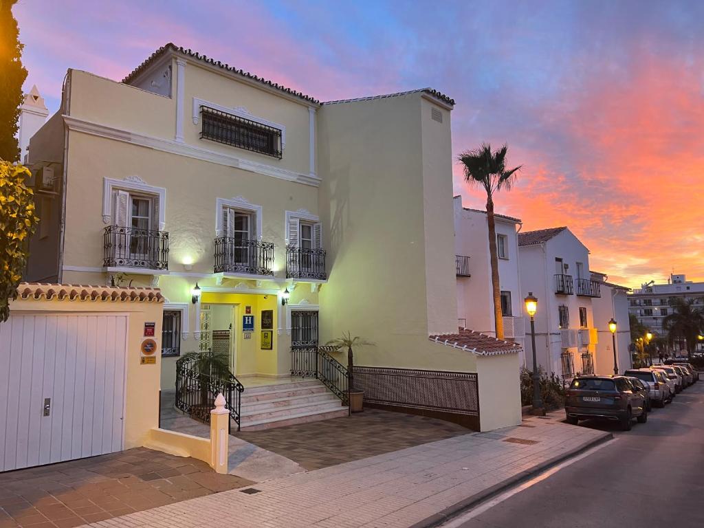 a white house with a palm tree in front of a street at Hotel Paraíso Del Mar in Nerja