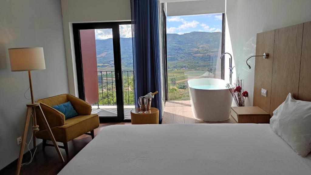 Schlafzimmer mit einem Bett, einer Badewanne und einem Fenster in der Unterkunft Belmonte Sinai Hotel in Belmonte