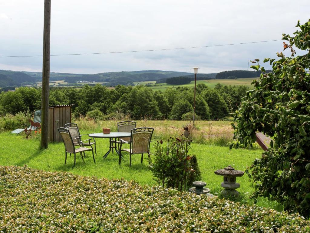 een tafel en stoelen in het gras in een tuin bij Luxurious farmhouse near the ski area in Hellenthal