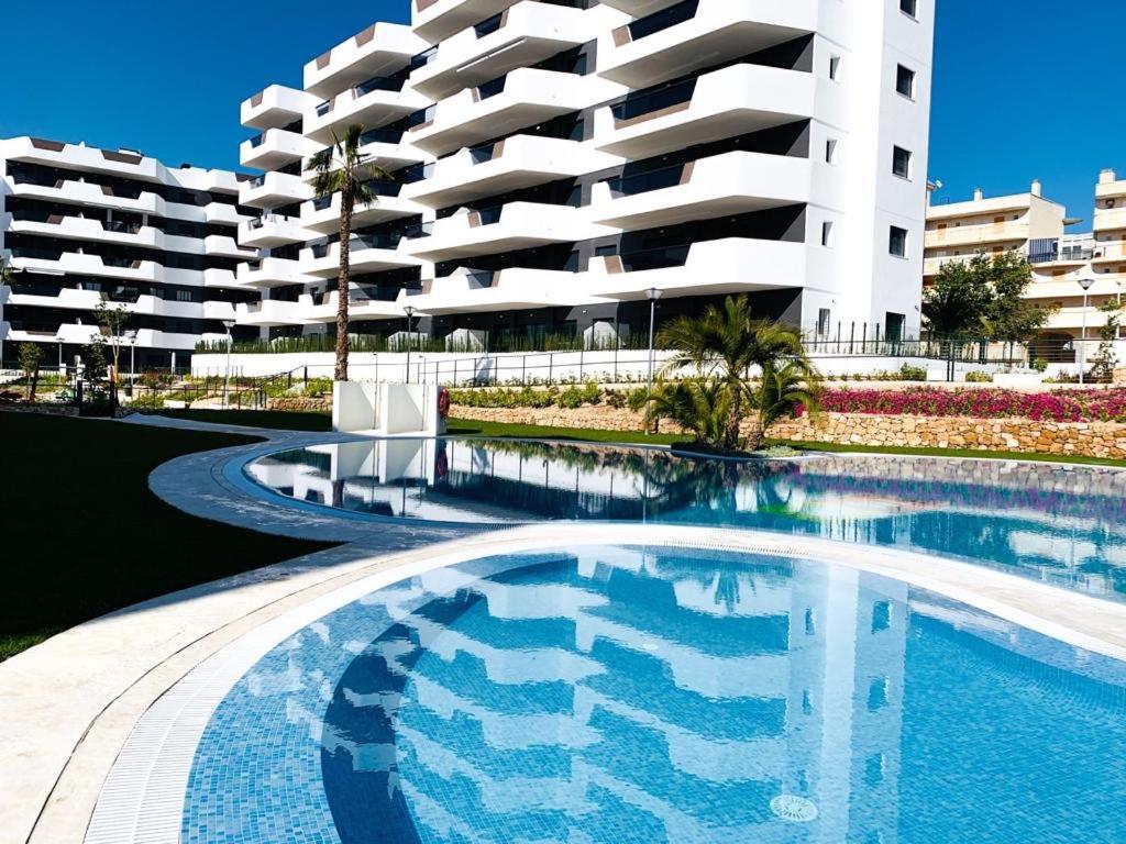 a swimming pool in front of a large building at Sol Blanco in Arenales del Sol