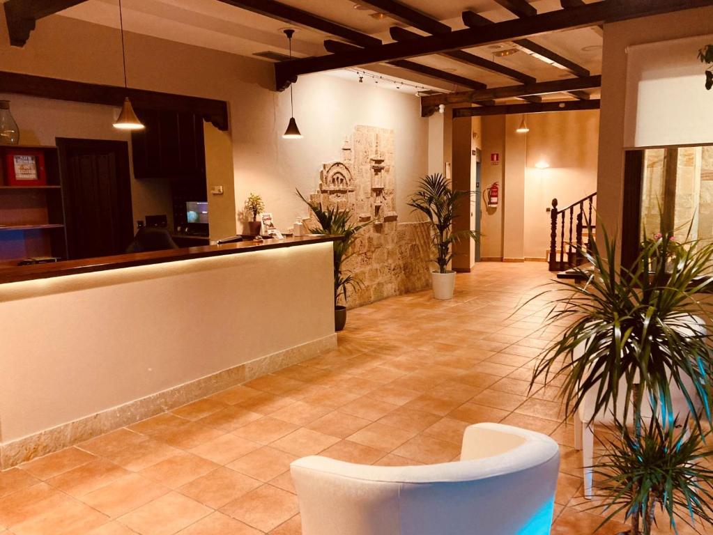 a lobby with a bar and plants in a building at Hotel Tharsis in Cazorla