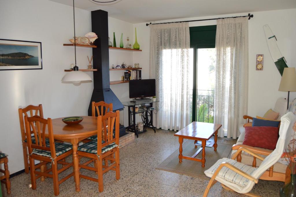 a living room with a table and chairs and a television at La Caseta in Tamariu