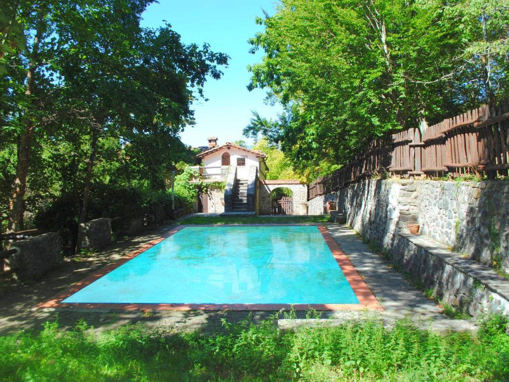 サン・マルチェッロ・ピストイエーゼにあるSpacious Holiday Home with shared poolの家屋を背景にした古いスイミングプール