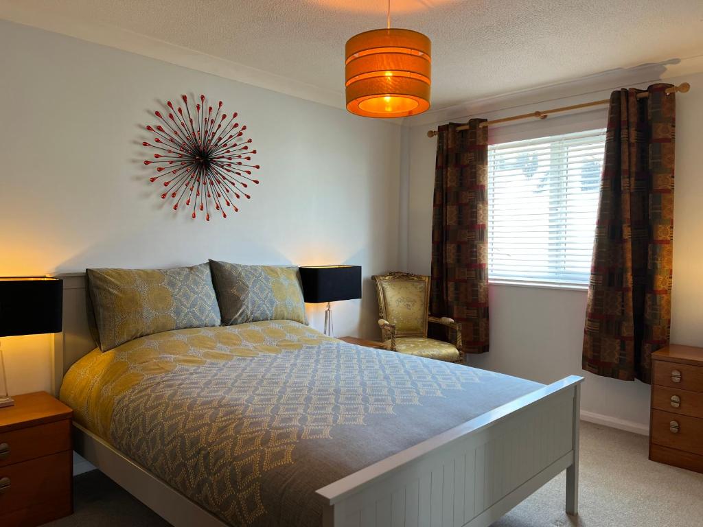 um quarto com uma cama grande e uma janela em Atlantic apartment em Sidmouth