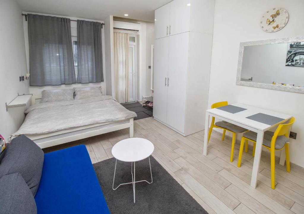 a living room with a bed and a table and chairs at Studio Apartment Lukas in Vinkovci