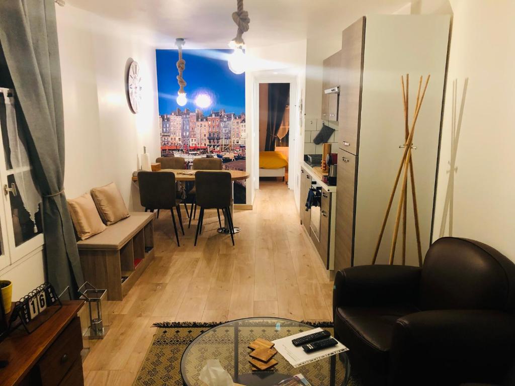 - un salon avec une table et une vue sur la ville dans l'établissement Le logis des lavandières, à Honfleur