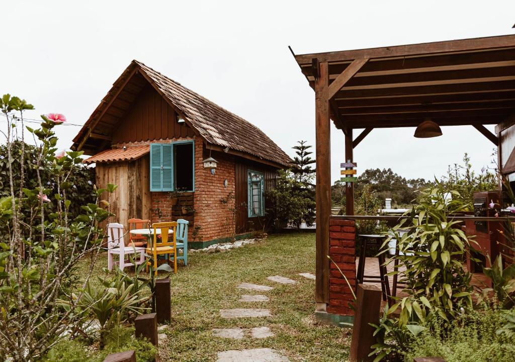 uma casa com uma mesa e cadeiras em frente em Chalé Sol com hidromassagem em meio a natureza em Piçarras