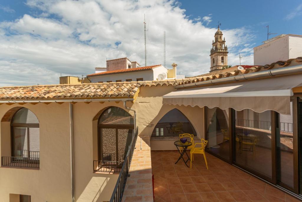 un balcon d'un immeuble avec une tour d'horloge dans l'établissement Casa Verònica, à Pego