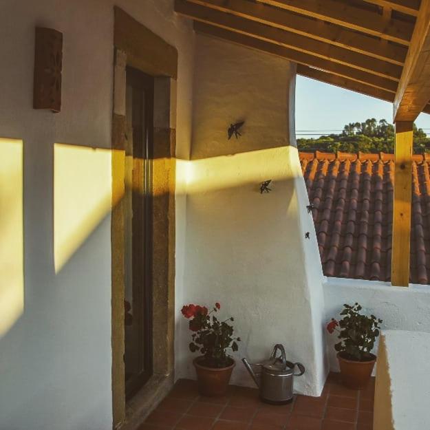 a house with two potted plants on a balcony at CASA ANDORINHAS in Fontainhas
