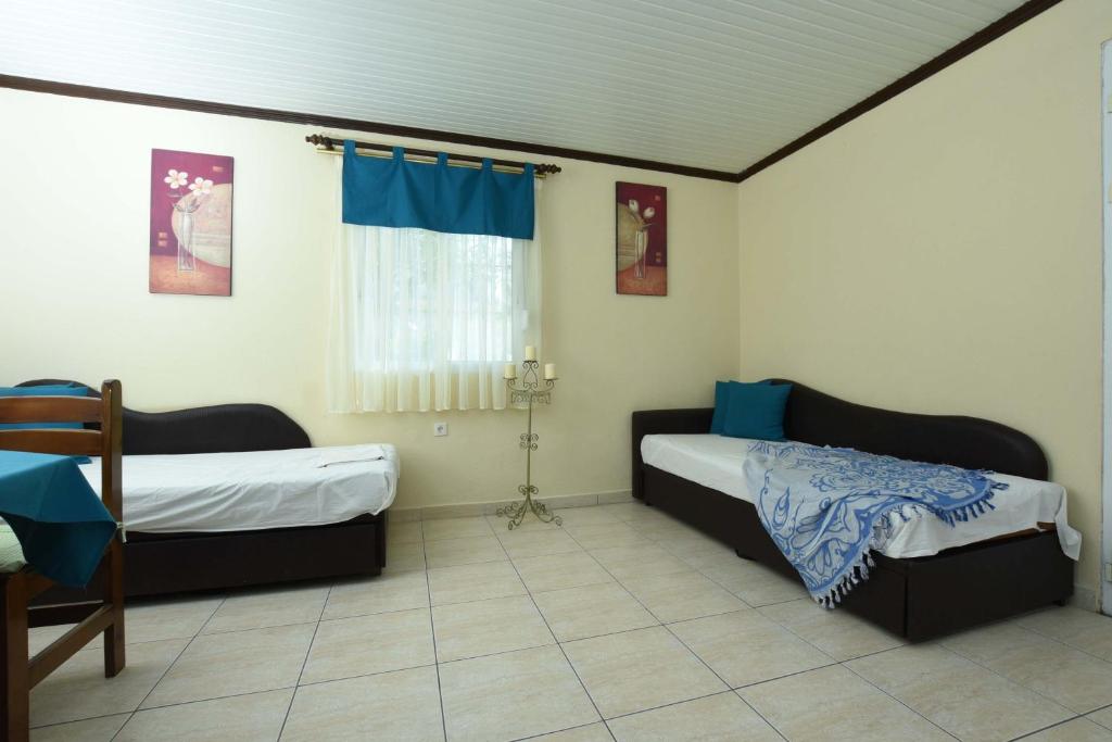 a bedroom with two beds and a window at Haus Platanos Apartments & Bungalows by the Sea in Vourvourou