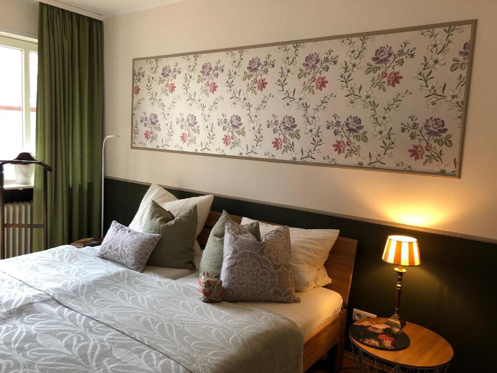 1 dormitorio con 1 cama con una pintura floral en la pared en Gästehaus Susanne Pfaffmann, en Landau in der Pfalz
