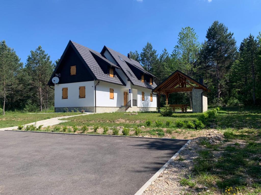ein großes weißes Haus mit schwarzem Dach in der Unterkunft The Starlings Apartments Plitvice Lakes in Plitvička Jezera