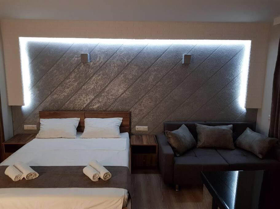 ein Schlafzimmer mit zwei Betten und einer Couch in der Unterkunft Tbilisi House in Tbilisi City