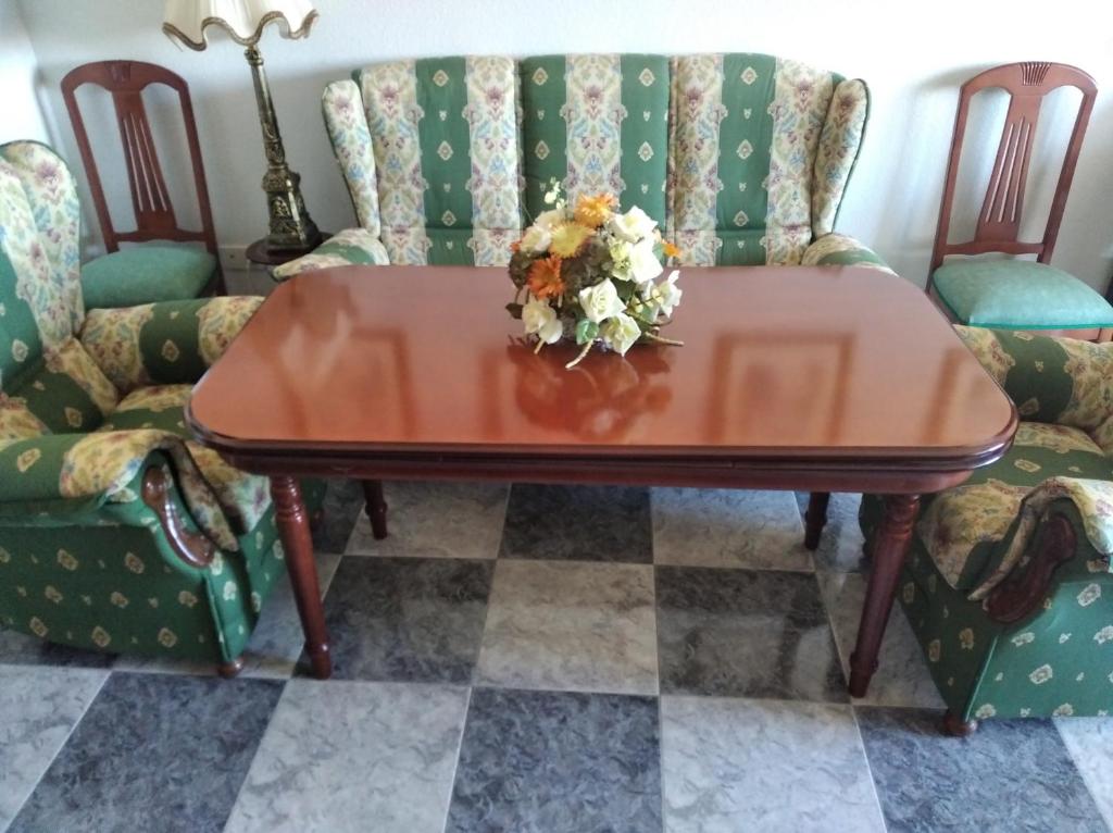 una mesa con un ramo de flores. en Apartamento soleado y amplio, en Plasencia