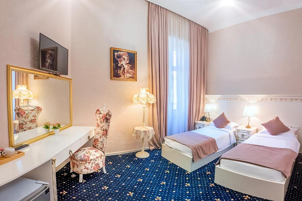 een hotelkamer met 2 bedden en een spiegel bij Vintage Hotel in Tbilisi City