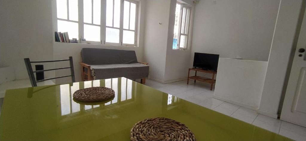 a living room with a green table and a couch at Samara's Home in Mindelo