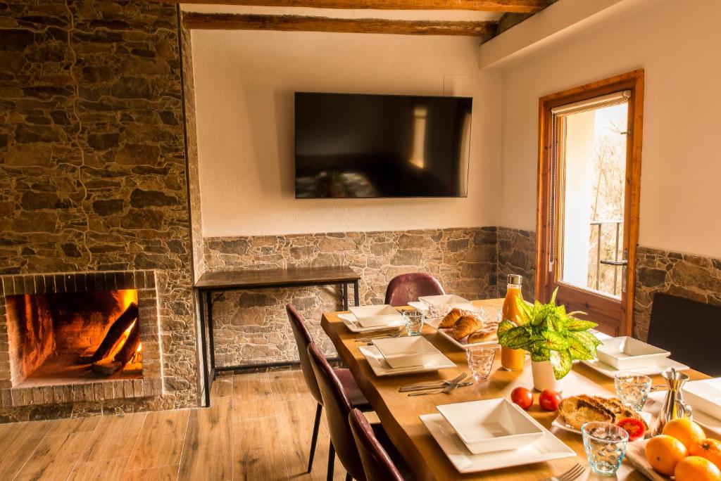 聖保德塞古列斯的住宿－Casa rural Can Miralter，一间带桌子和壁炉的用餐室