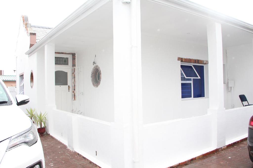 una casa blanca con una pared blanca en The White House Lodge, en Ciudad del Cabo