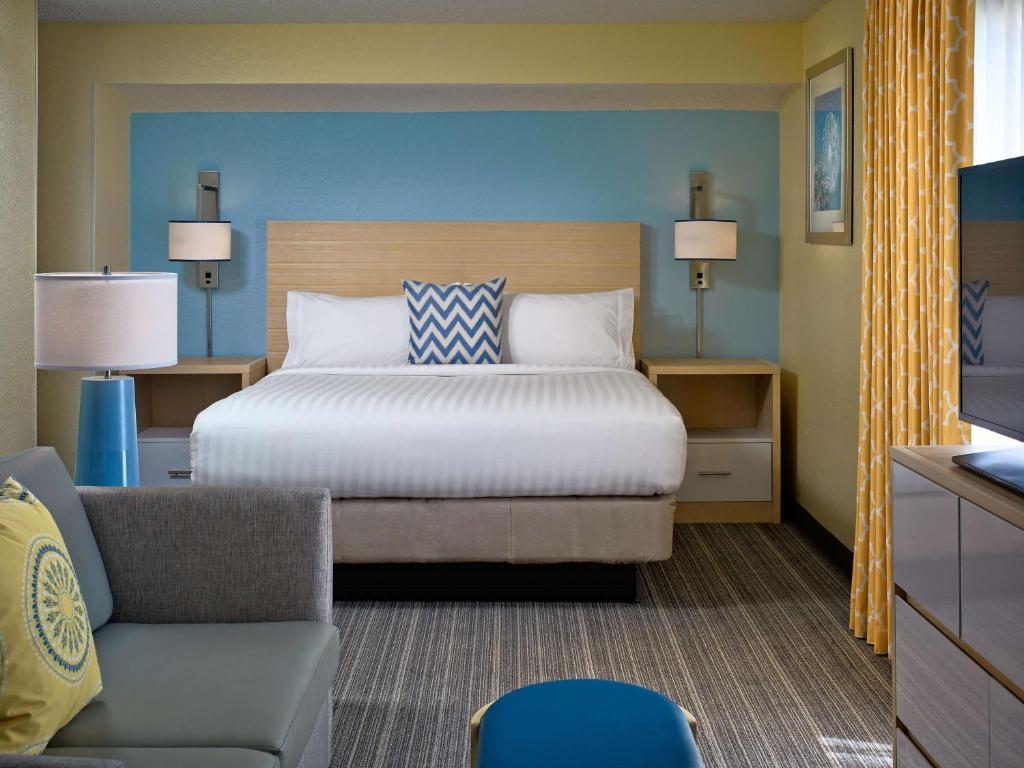 a bedroom with a bed and a couch and a chair at Sonesta ES Suites Burlington VT in Burlington