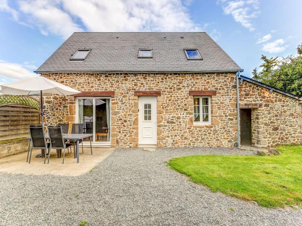 a stone house with a table and chairs in front of it at Normandy Family Retreat in Brainville