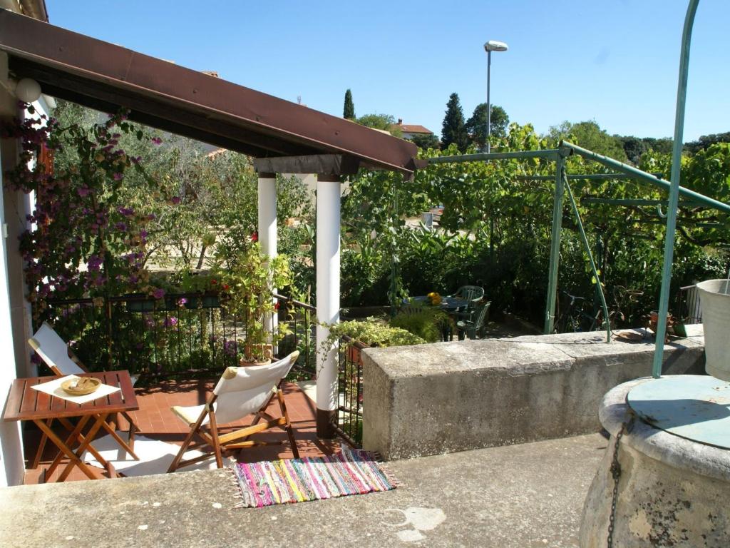 a patio with two chairs and a table and a fence at Charming Holiday Home in Pula near Beach in Štinjan