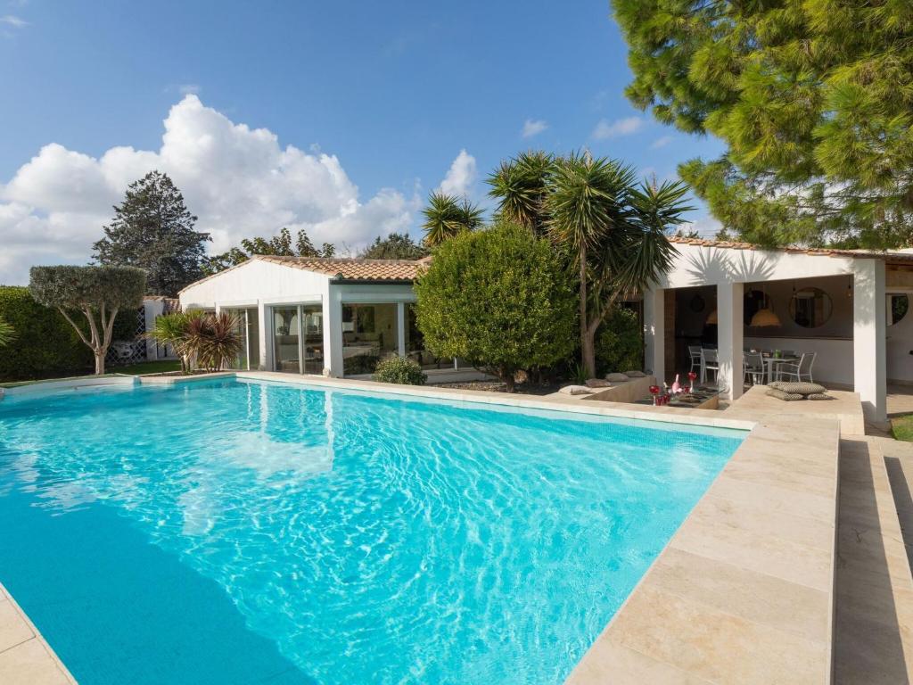 a large blue swimming pool in front of a house at Magnificent villa with private pool in Narbonne