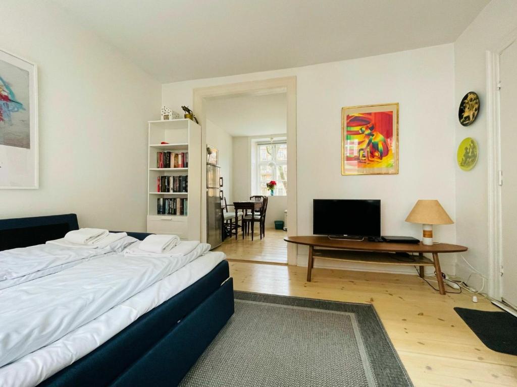um quarto com uma cama, uma secretária e uma televisão em ApartmentInCopenhagen Apartment 200 em Copenhague