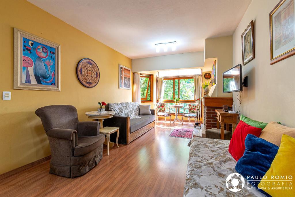 uma sala de estar com um sofá e uma mesa em Apartamento Aluguel Temporada Gramado em Gramado
