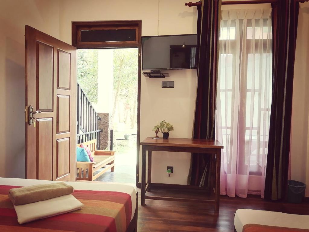 a room with a bed and a door with a window at Ceylonima Home Stay in Anuradhapura