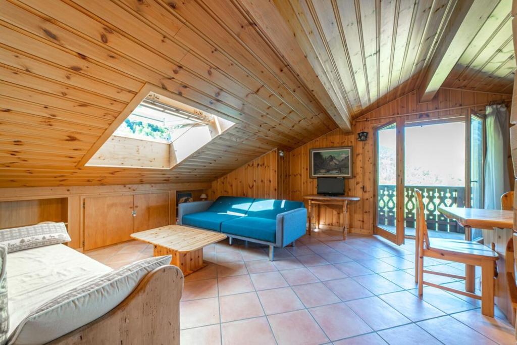 ein Wohnzimmer mit einem blauen Sofa und einem Fenster in der Unterkunft Gentiane Furnished flat in Les Houches