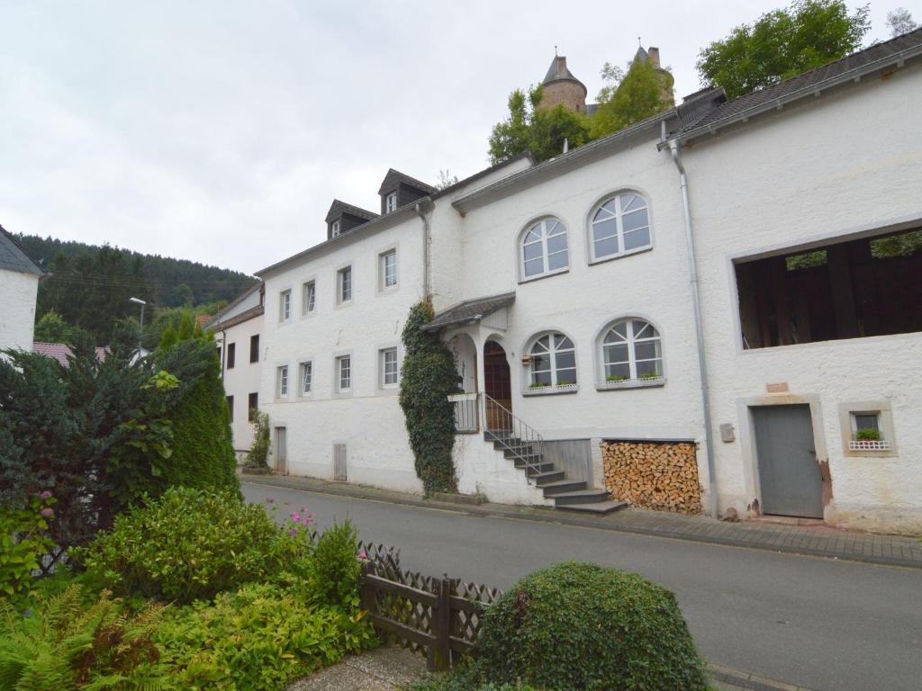 MürlenbachにあるVery comfortable house with bathrooms and a gardenの道路横の白い建物