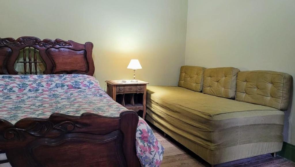 1 dormitorio con cama, sofá y mesa en CASONA EL PALENQUE de Vieytes en Álvarez Jonte
