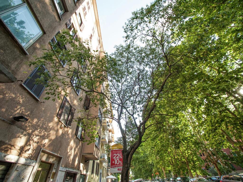 ローマにあるSpavious Apartment in Rome with city viewの通りの建物前の木